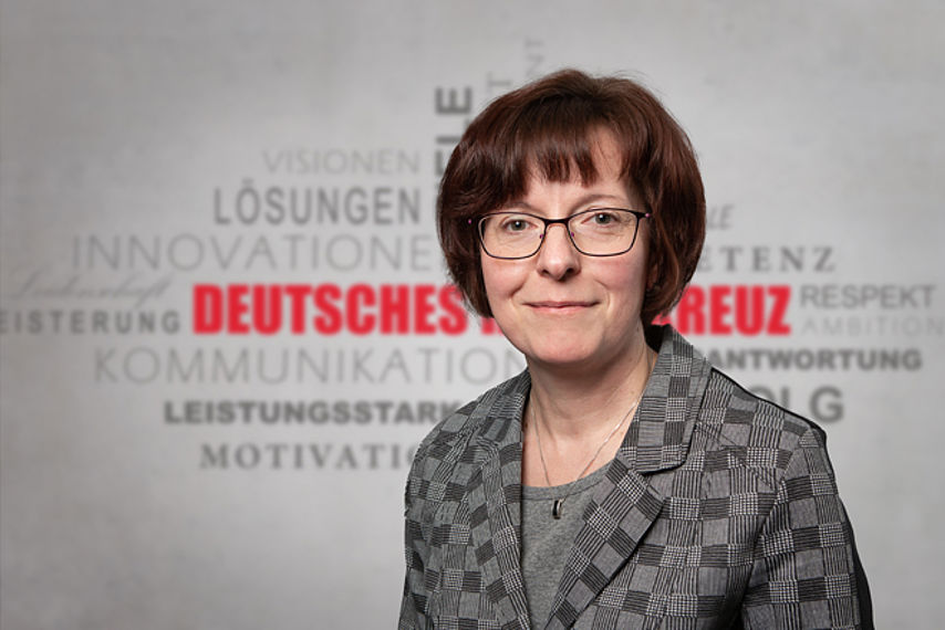 Silvia Lang Mitarbeiterfoto vor Rotkreuz-Hintergrund