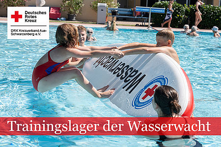 Zwei Kinder im Freibad mit einem Rettungsbrett der Wasserwacht