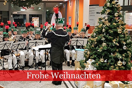 Dirigent im Bergmannshabit vor Orchester und Weihnachtsbaum