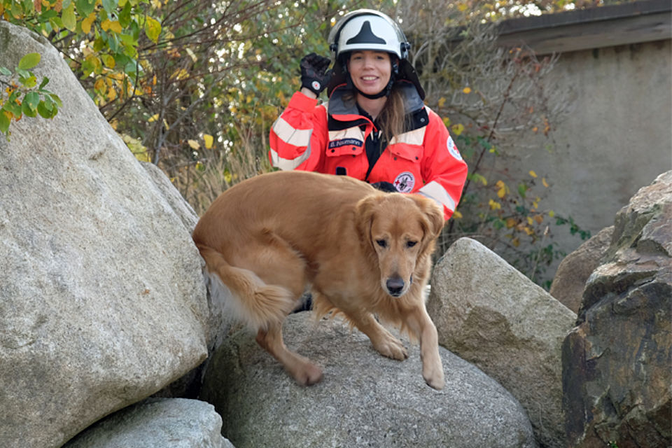 Hundeführer und Hund im unwegsamen Gelände